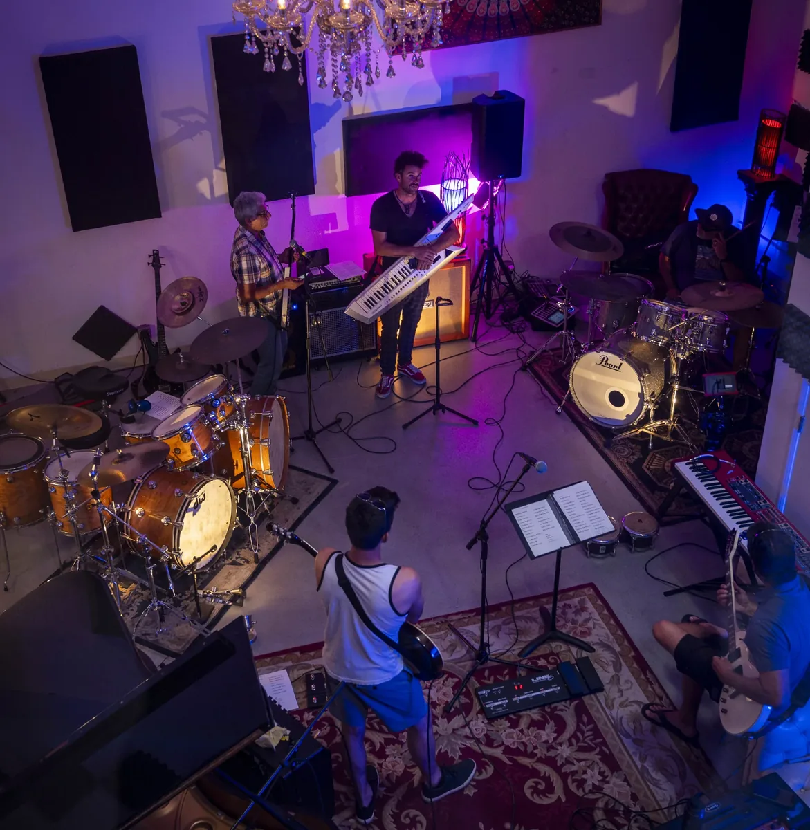 A band tracking live in the studio under stage lighting