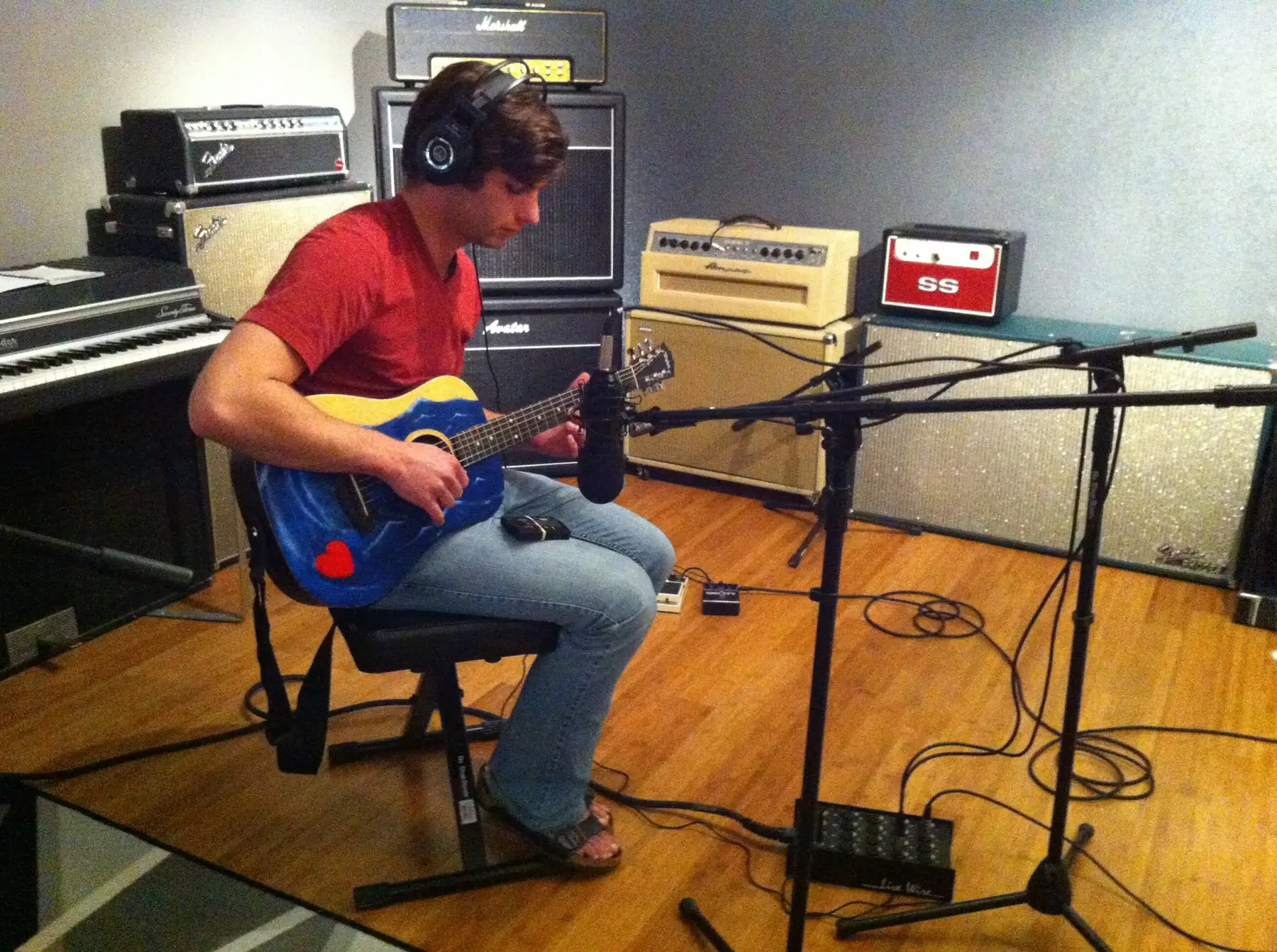 A student's first guitar lesson surrounded by amps