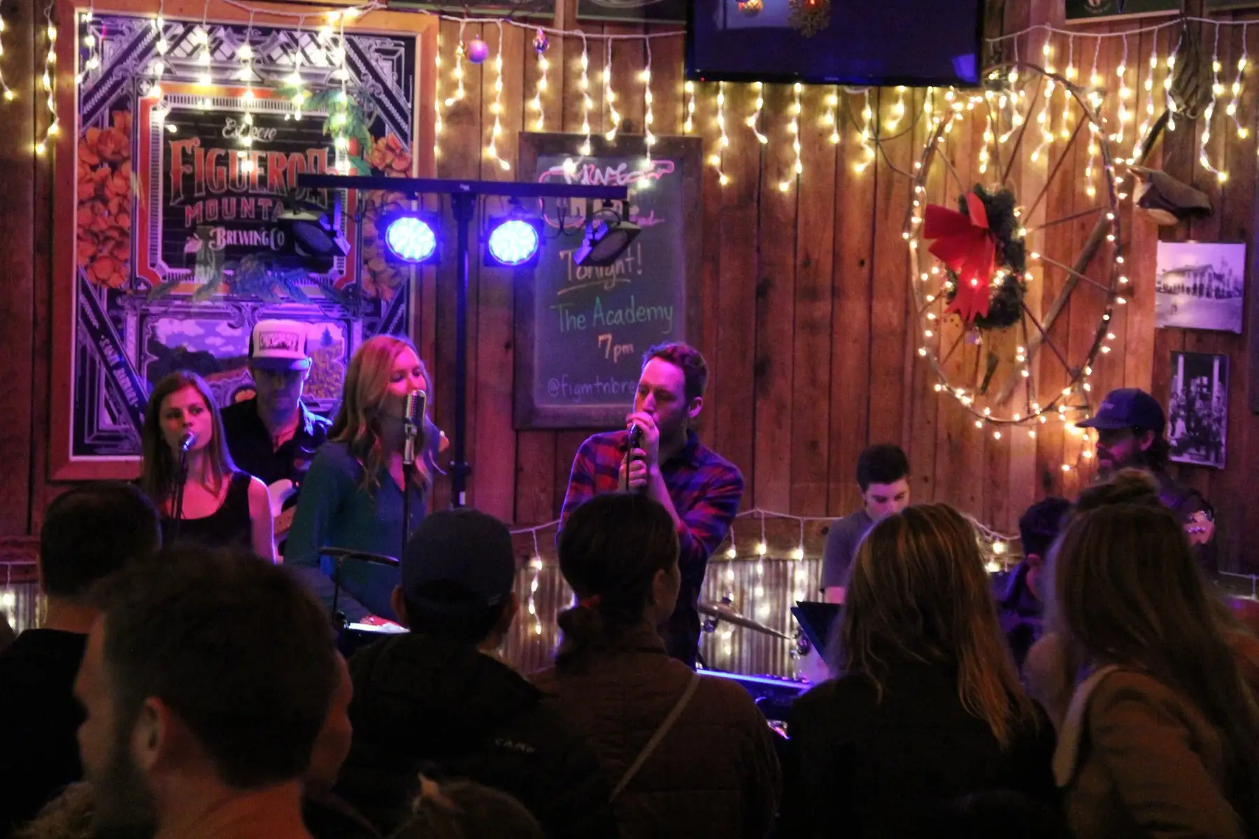 Student band performing under string lights