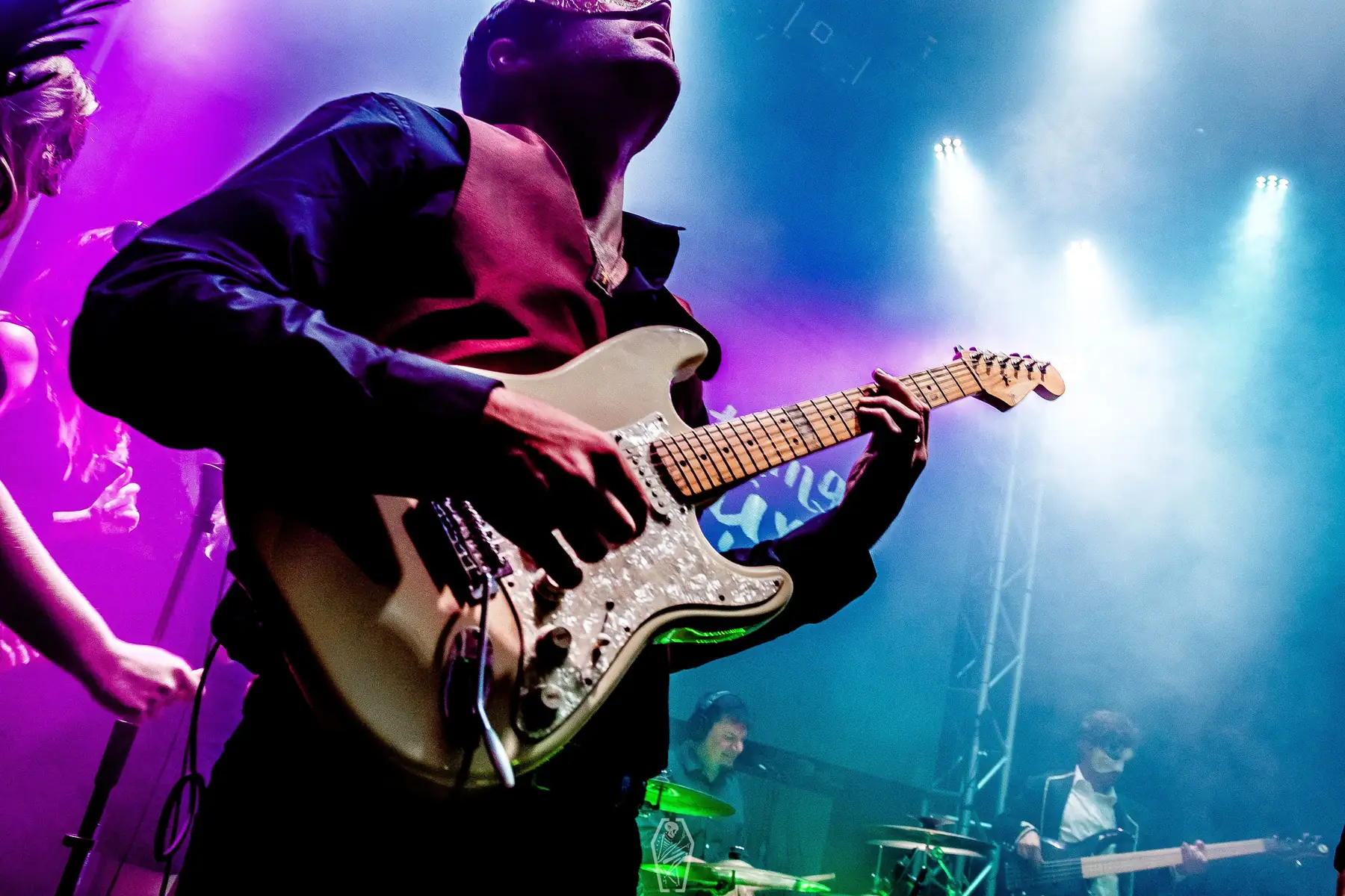 Guitarist on a concert stage in purple light